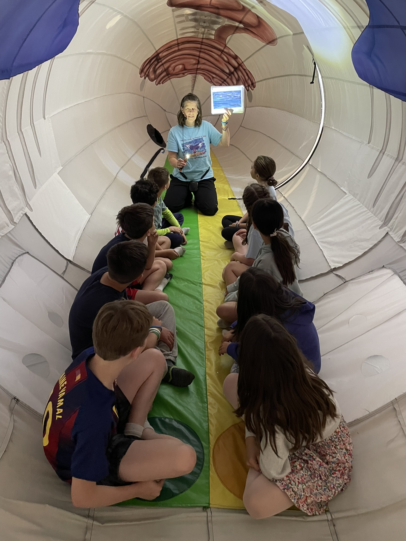 Educator teaching children about whales on a whale watch boat