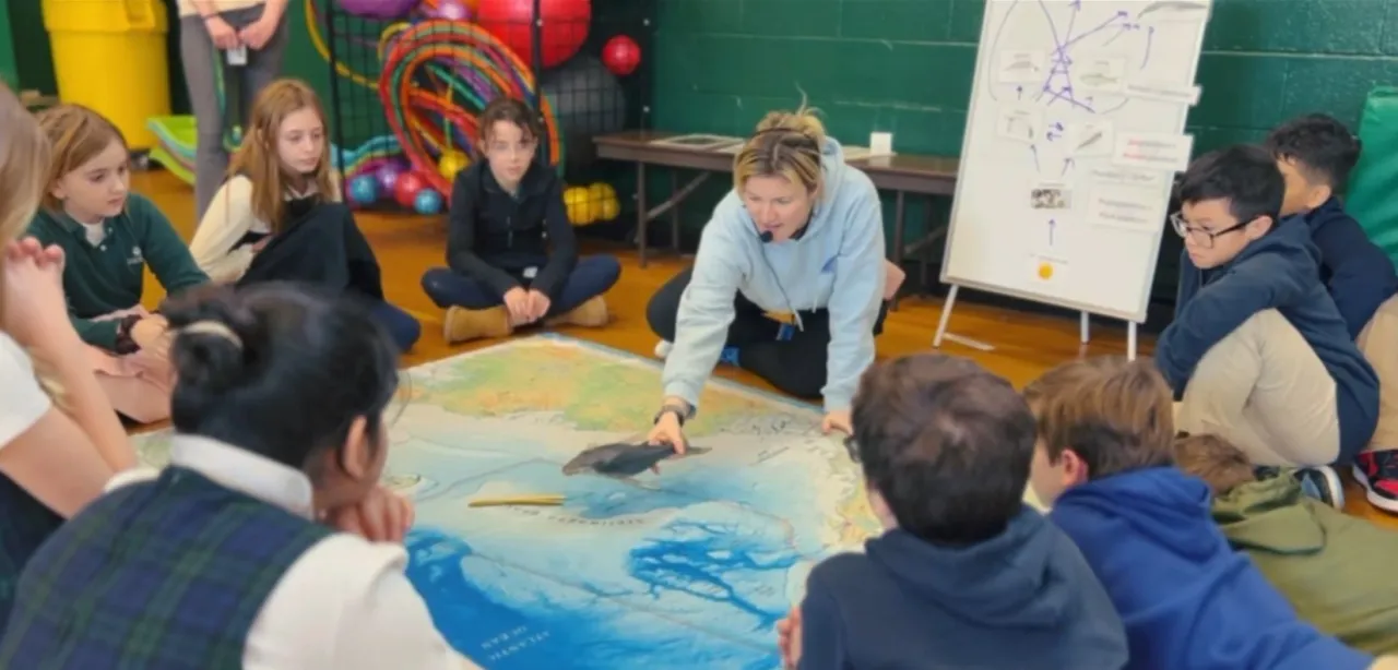 Cynde teaching students around a whale migration map inside the Whale Mobile